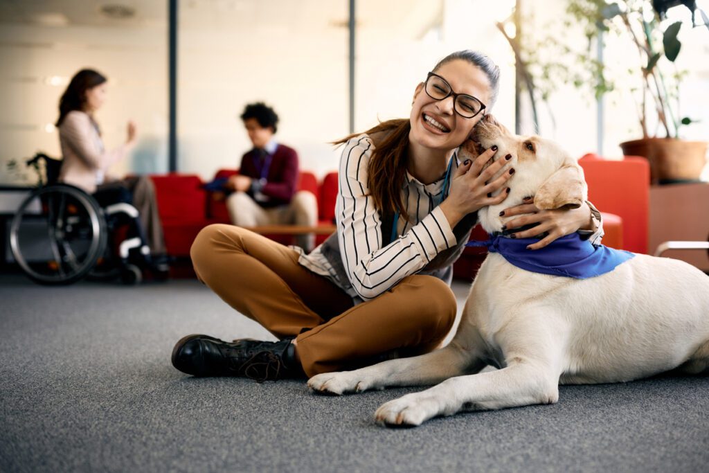 A woman sitting on the ground with her dog.