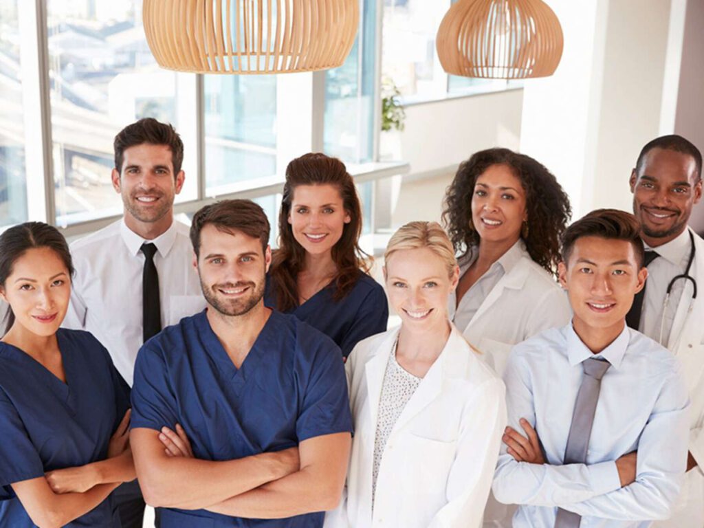 A group of doctors and nurses standing in front of a window.