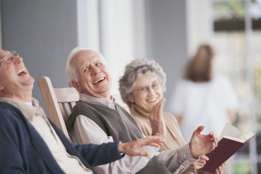 A couple of people sitting in chairs laughing.